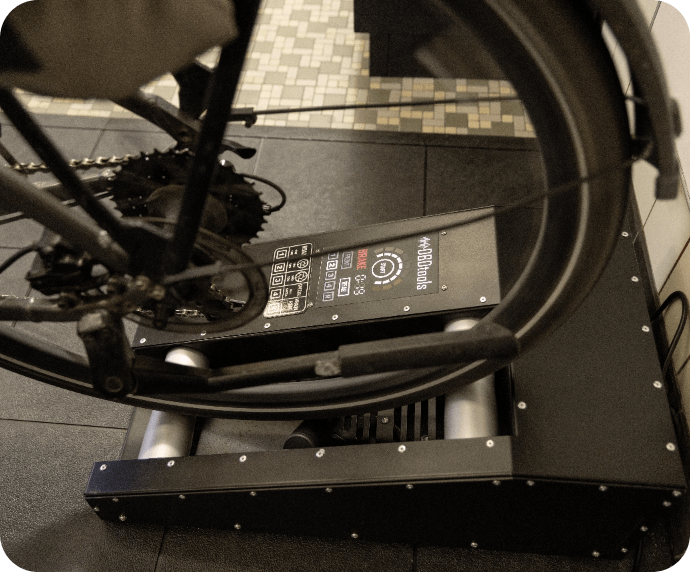 Fahrrad läuft auf einem Rollenprüfstand in der Werkstatt.